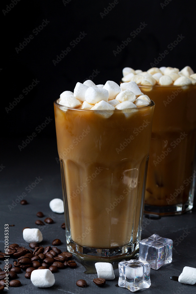 chocolate with marshmallows.Tasty Ice coffee with marshmallow in a tall glass. Cold drink with coffee beans and ice on the black table. Cold summer drink on the black background with copy space. chocolate with marshmallows.Tasty Ice coffee with marshmallow in a tall glass. Cold drink with coffee beans and ice on the black table. Cold summer drink on the black background with copy space.