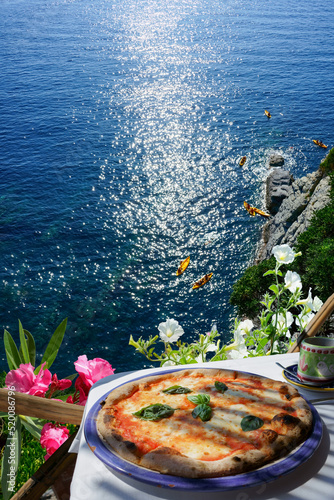  Pizza served on terrace with view to a beautiful Portofino coast. Liguria, Italian riviera