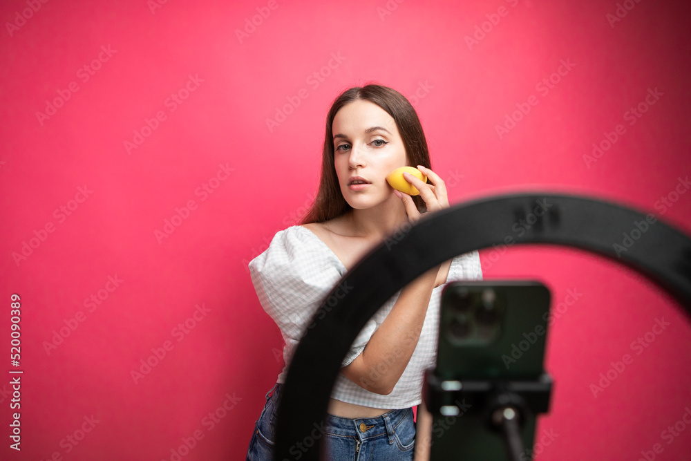 Beauty blogger recording makeup tutorial on pink background Beauty blogger recording makeup tutorial on pink background