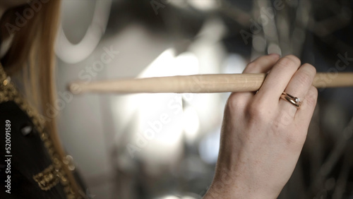 Close-up of hand with drumstick. Action. Female hand professional drummer holds wooden drumstick before playing at music rehearsal