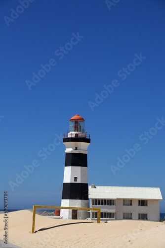 Cape Recife lighthouse on sandy dune at Nelson Mandela Bay with blue sky and sunlight