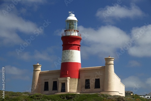 front view of Cape Agulhas Lighthouse in red and white, blue sky