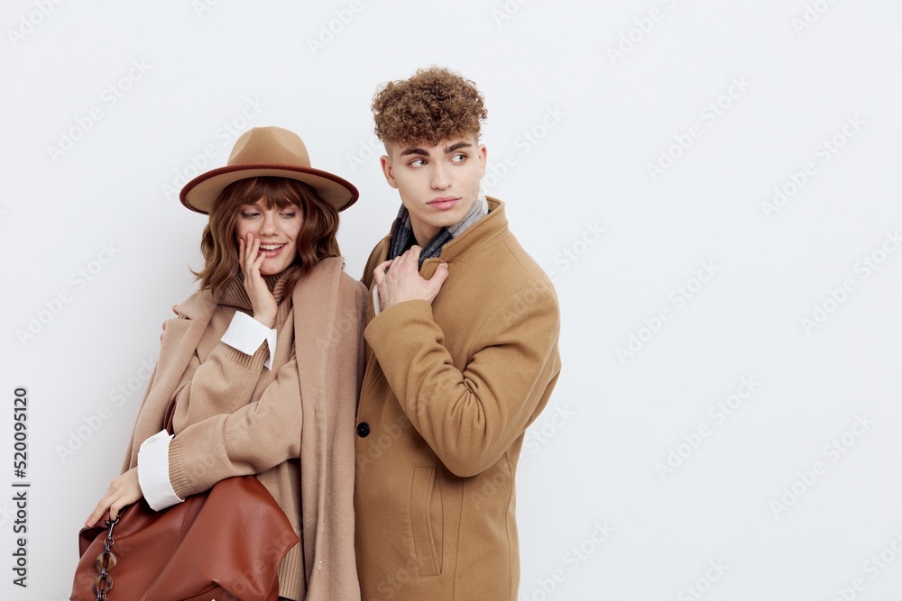a happy couple a man and a woman stand in stylish autumn clothes on a white background close to each other and smile happily a happy couple a man and a woman stand in stylish autumn clothes on a white background close to each other and smile happily