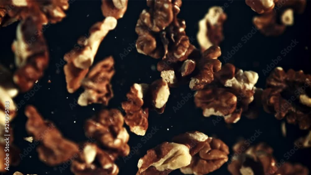 Peeled walnut rises up and falls down. Top view. On a black background. Filmed is slow motion 1000 fps.