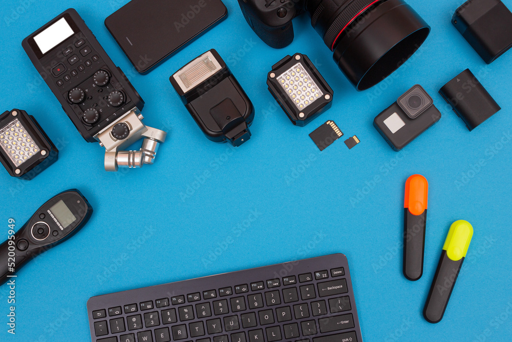 Top View of Photographer's, Videographer's or Video Blogger's Workplace. Digital Gadgets Lying on Blue Table - Flat Lay