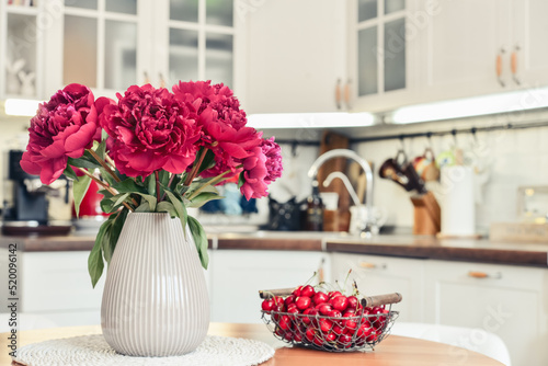 Fototapeta Naklejka Na Ścianę i Meble -  Bouquet of purple peony flowers in interior of the kitchen