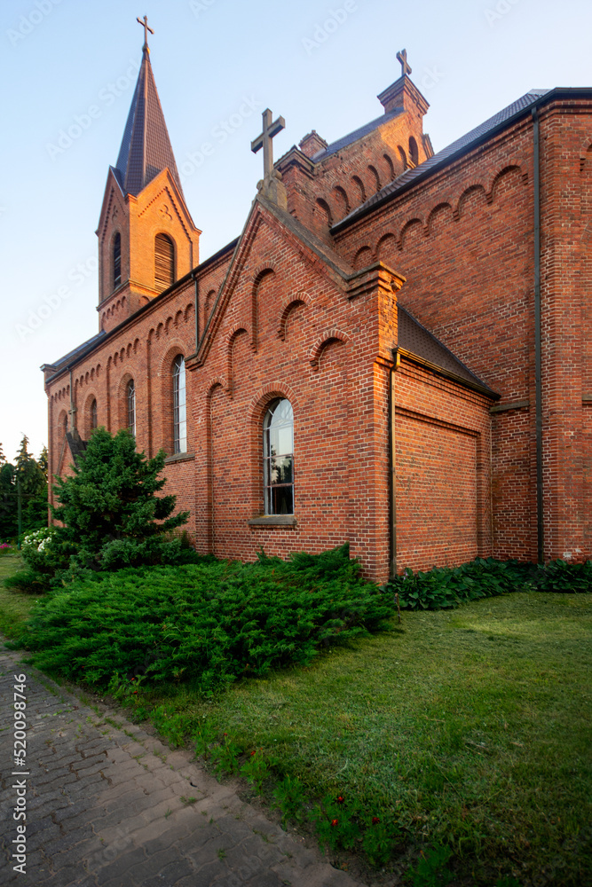 Church of St. John the Baptist in the village of Opsa, Belarus. Neo-Gothic church made of red brick with one bell tower and low symmetrical sacristy.
