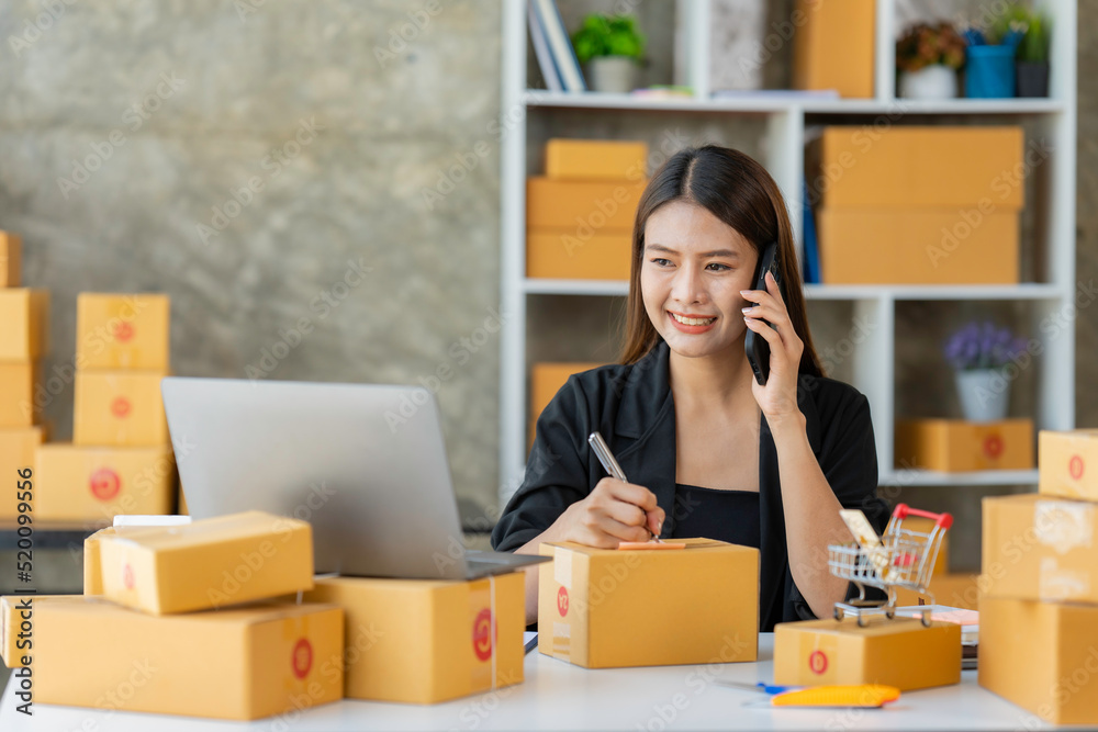 Startup SME small business entrepreneur woman using phone call receive from customer checking product on stock at home office, online marketing packaging delivery box, SME e-commerce concept. Startup SME small business entrepreneur woman using phone call receive from customer checking product on stock at home office, online marketing packaging delivery box, SME e-commerce concept.