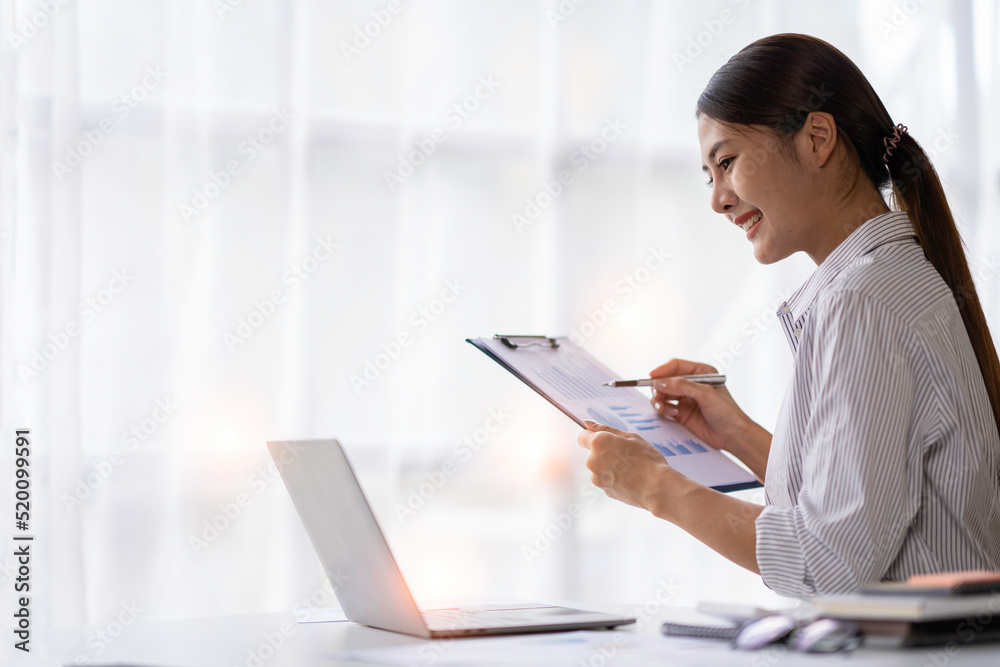 Portrait of Asian businesswoman with laptop Makes video calls and online meetings with colleagues at her office. Young woman working on a laptop in the office. Portrait of Asian businesswoman with laptop Makes video calls and online meetings with colleagues at her office. Young woman working on a laptop in the office.