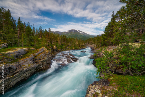 Venue Asbjorn fosse  Norwegian landscape  a view of the mountains  a mountain stream flows below  and the mountain slopes are covered with grass and shrubs 