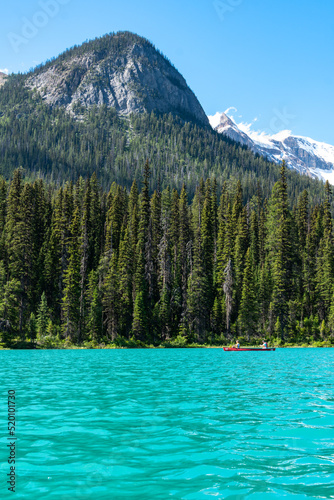 Tourists canoe on the teal water of Emerald Lake in Yoho National Park Canada