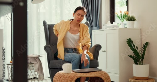 Youth asia female girl or university student stand front sofa chair put computer laptop on table feel pain, hurt in back from hard work in living room at home. Office syndrome, Life balance concept.
