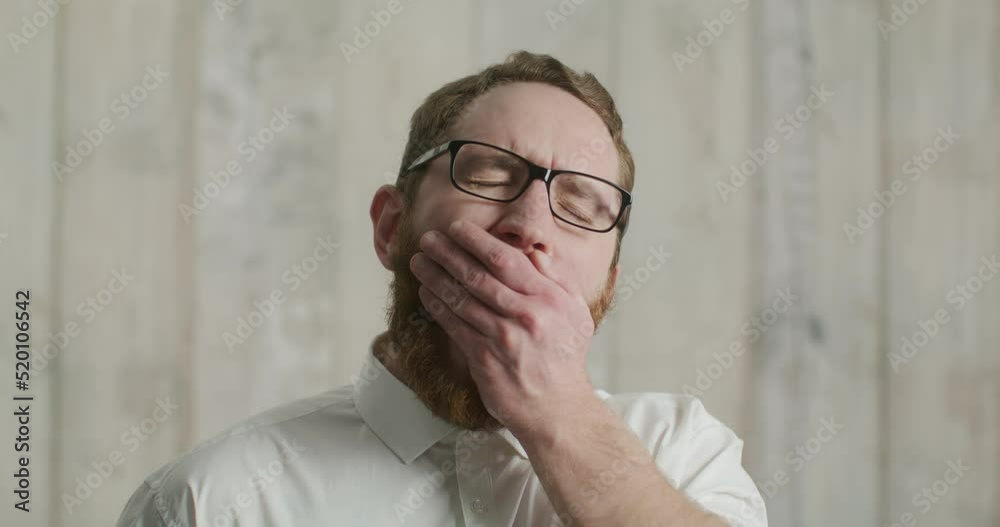 portrait of an attractive man yawning in a white shirt portrait of an attractive man yawning in a white shirt