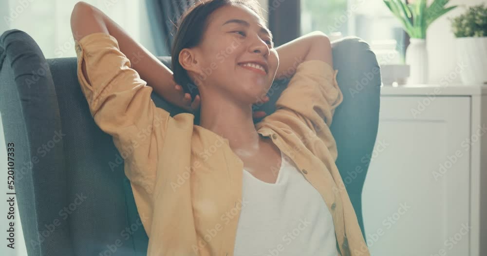 Close-up Youth asia female girl or university student sit on sofa chair take a rest relax feel chill and calm after finish work in living room at house. Environment at home, Work life balance concept.