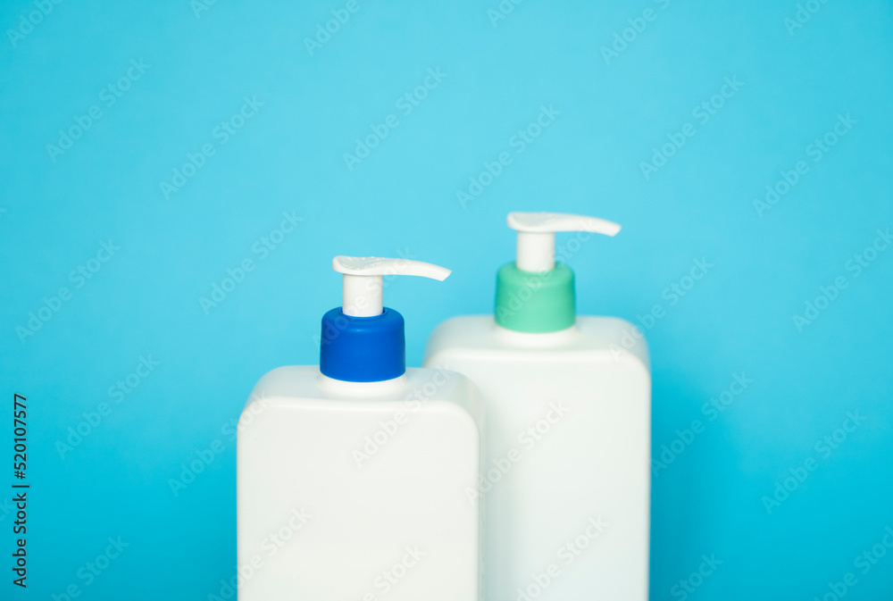 Liquid container for gel, lotion, cream, shampoo, bath foam. Cosmetic plastic bottle with dispenser pump on blue background. Cosmetic packaging mockup with copy space. Liquid container for gel, lotion, cream, shampoo, bath foam. Cosmetic plastic bottle with dispenser pump on blue background. Cosmetic packaging mockup with copy space.