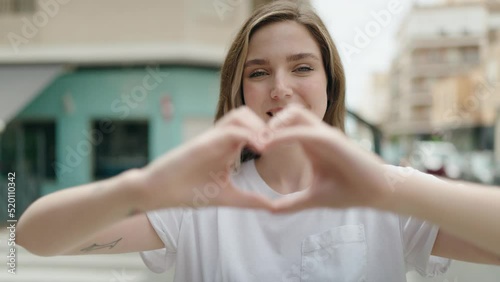 Wallpaper Mural Young woman smiling confident doing heart gesture with hands at street Torontodigital.ca