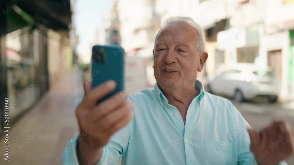 Senior grey-haired man smiling confident having video call at street Senior grey-haired man smiling confident having video call at street