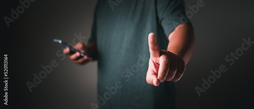 Businessman using mobile phone pointing up and showing with thumb up for touch © oum