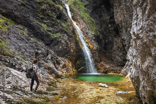 Woman Hiker Discover one of Beautiful Zapotoski Waterfalls in Zadnja Trenta Valley Slovenia photo