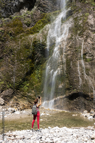Female Hiker Taking Some Photographs With Her Phone Of beautiful Brinta Waterfall in Slovene Julian Alps Under Mount Krn - Kobarid Suburbs