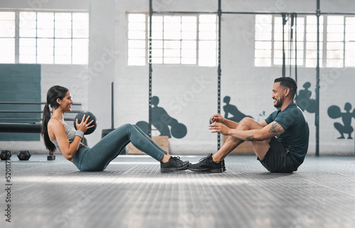 Active, sporty fitness couple or gym partners training together, doing core exercises with heavy equipment. Male trainer and female athlete having a fun workout session or class to build strength