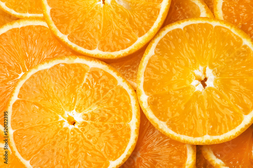 Orange background. Round juicy orange slices, top view.