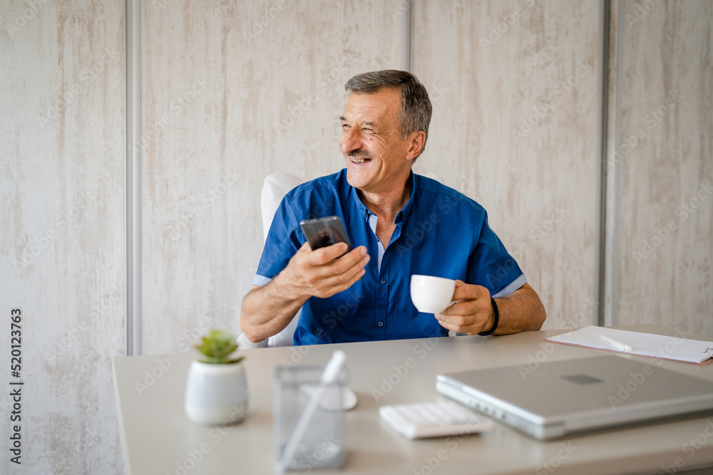 one man senior entrepreneur active caucasian male making a phone call talking while sitting at the desk table working at office manager and small business real people copy space one man senior entrepreneur active caucasian male making a phone call talking while sitting at the desk table working at office manager and small business real people copy space