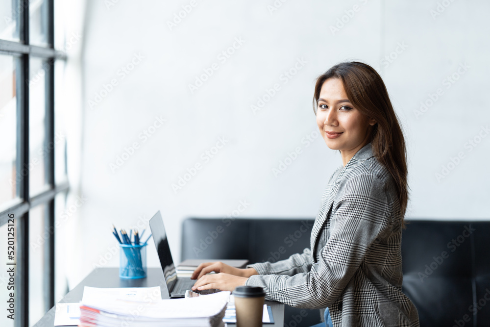 Asian woman working with laptop in her office. business financial concept. Asian woman working with laptop in her office. business financial concept.