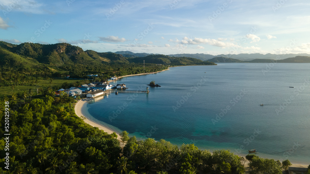 drone view of tropical island, hills and forest by the beach in the evening