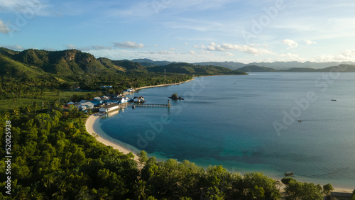 drone view of tropical island, hills and forest by the beach in the evening © ady sanjaya