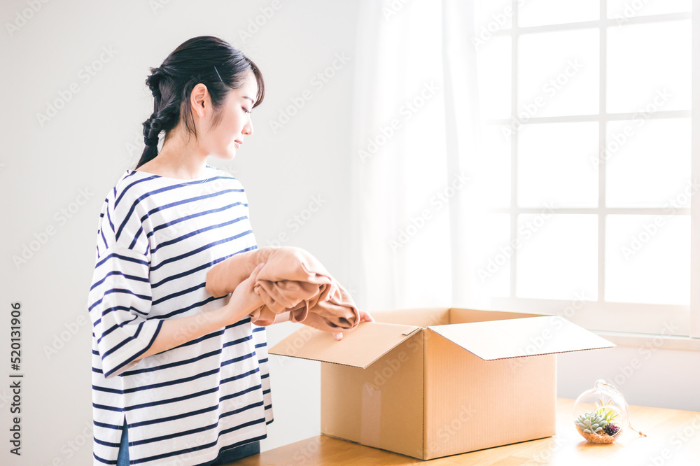 古着をフリマアプリに出品する女性(梱包)
古着をフリマアプリに出品する女性(梱包)