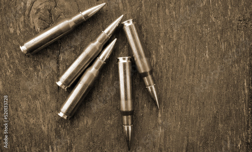 Rifle cartridges on a camouflage background. Top view. Sepia