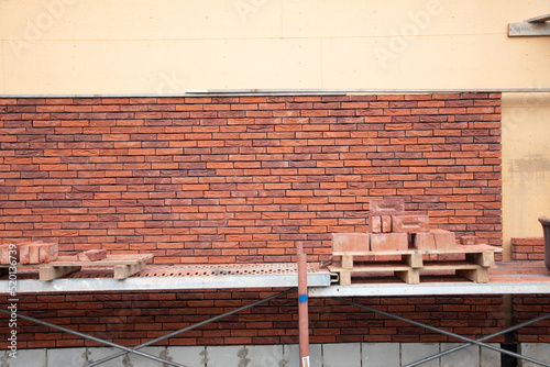 a new House is being built, the beginning of brickwork with red bricks, building