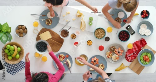 Fun, healthy and creative cooking for children using fresh, nutritious and organic food. Top view of young people using natural fruits, cereals and berries to make cute kids meals at home or school