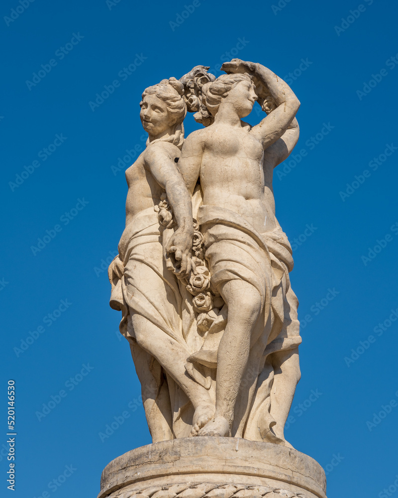 View of the statue of the Three Graces, elegant stone sculpture of the fountain on the famous landmark Place de la Comedie, Montpellier, France View of the statue of the Three Graces, elegant stone sculpture of the fountain on the famous landmark Place de la Comedie, Montpellier, France