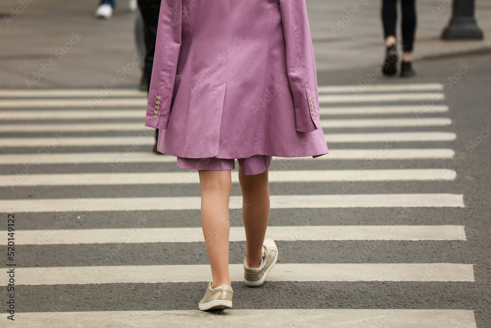 Legs of people walking on a pedestrian crossing Legs of people walking on a pedestrian crossing