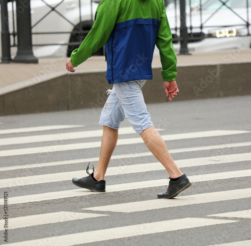 Legs of people walking on a pedestrian crossing
