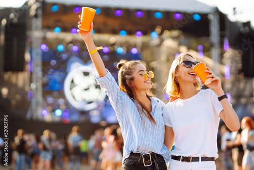 Two young woman with beer at beach party. Summer holiday, vacation concept. Friendship and celebration concept. photo