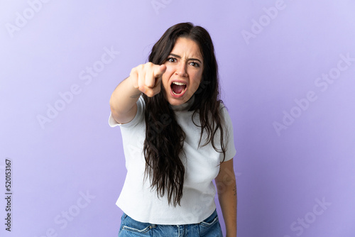 Young caucasian woman isolated on purple background frustrated and pointing to the front
