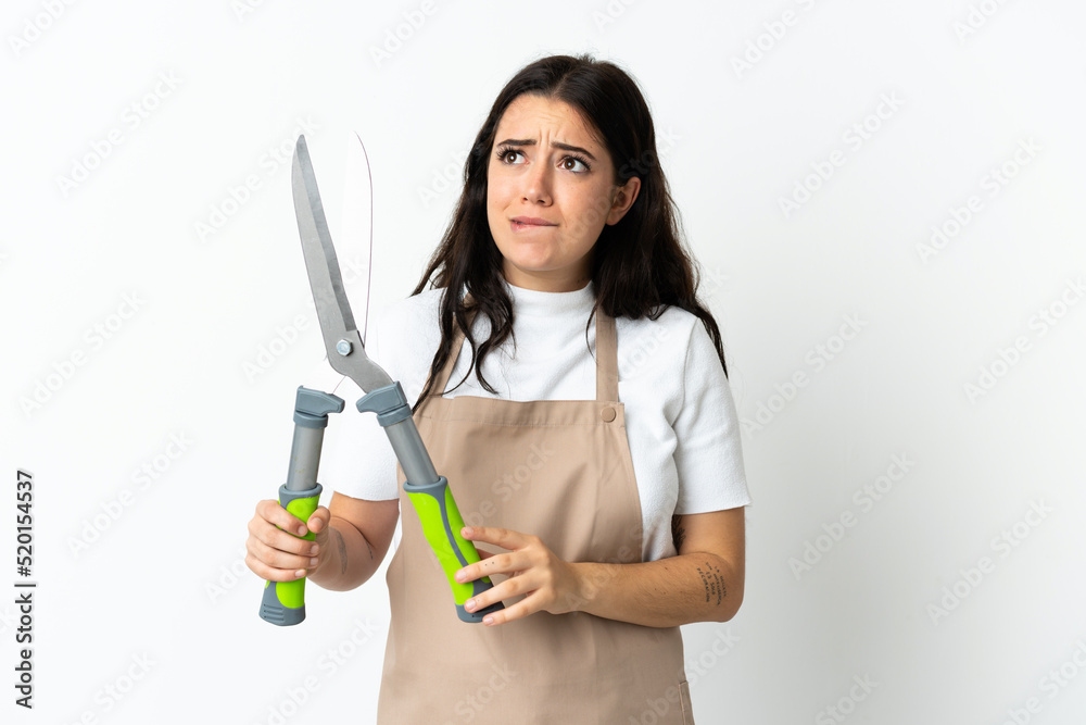 Young caucasian woman holding a plant isolated on white background having doubts and thinking Young caucasian woman holding a plant isolated on white background having doubts and thinking
