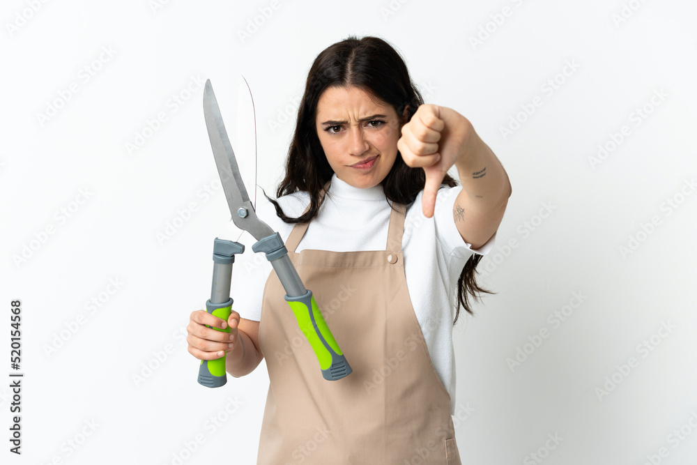 Young caucasian woman holding a plant isolated on white background showing thumb down with negative expression Young caucasian woman holding a plant isolated on white background showing thumb down with negative expression