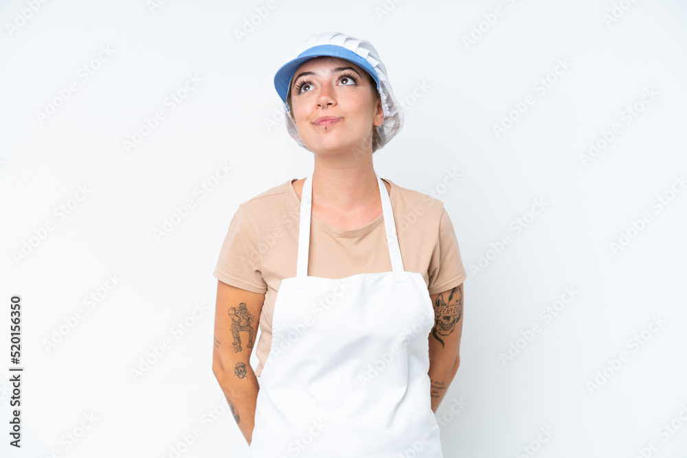 Fishmonger wearing an apron and holding a raw fish isolated on white background and looking up Fishmonger wearing an apron and holding a raw fish isolated on white background and looking up