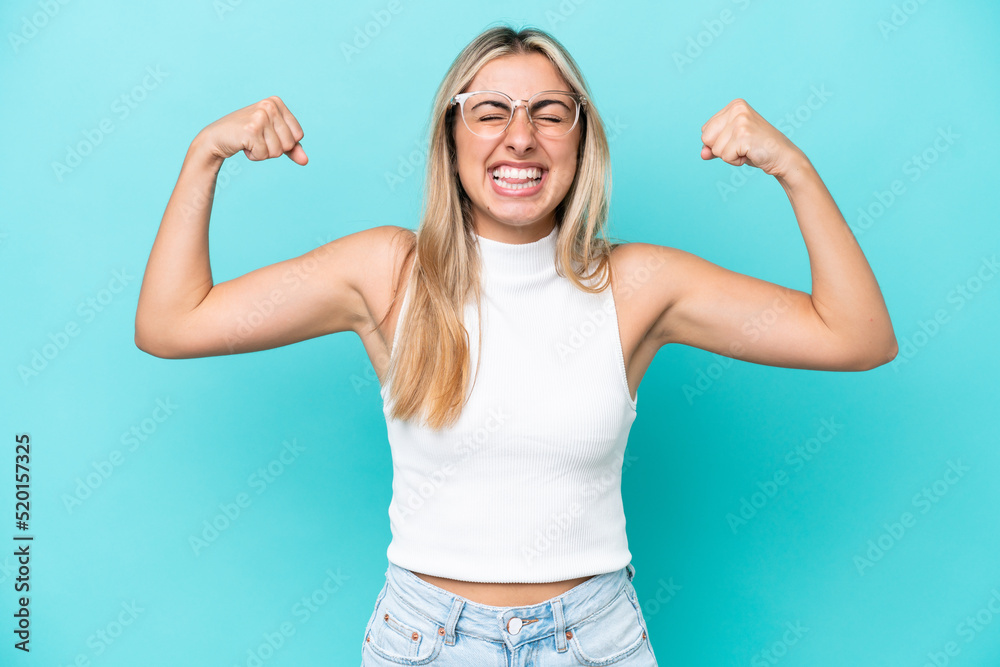 Young caucasian woman isolated on blue background doing strong gesture Young caucasian woman isolated on blue background doing strong gesture