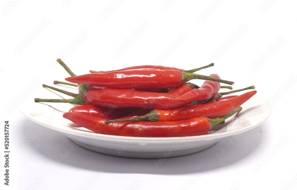 white background Fresh red peppers are placed in a white floral dish. white background Fresh red peppers are placed in a white floral dish.