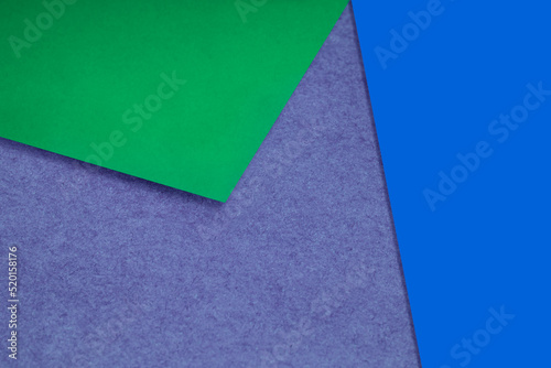 Plain and Textured pastel blue purple green papers randomly laying to form M like pattern and triangle for creative cover design idea
