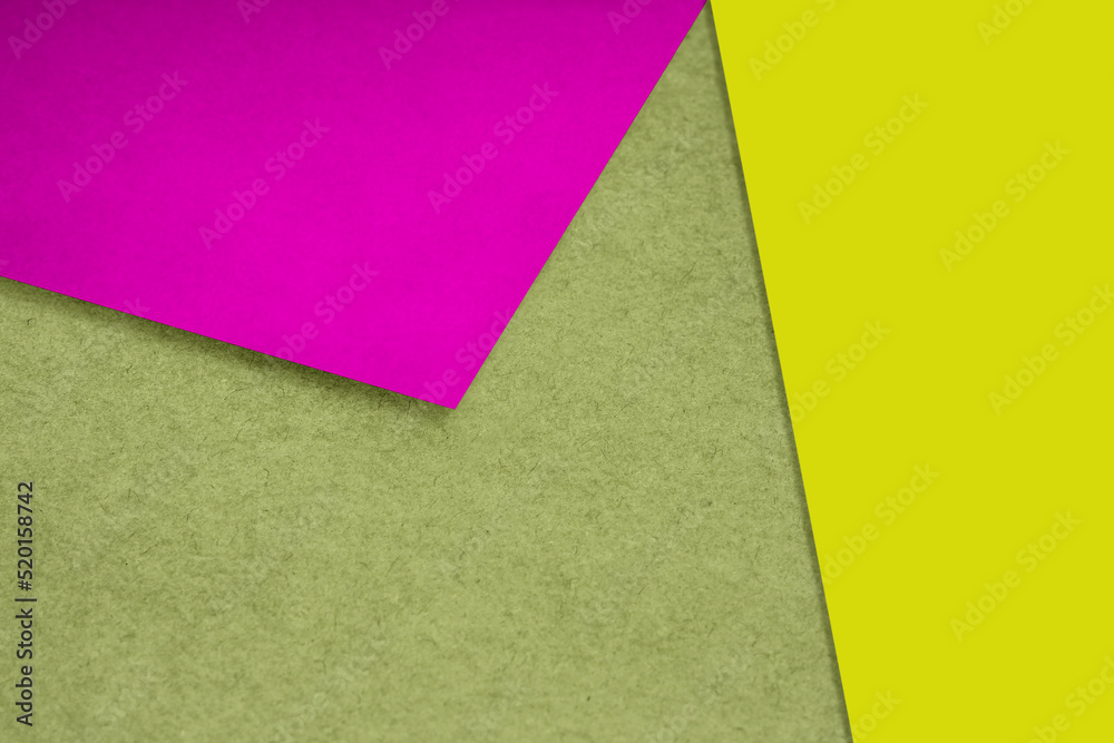 Plain and Textured neon pink yellow green papers randomly laying to form M like pattern and triangle for creative cover design idea