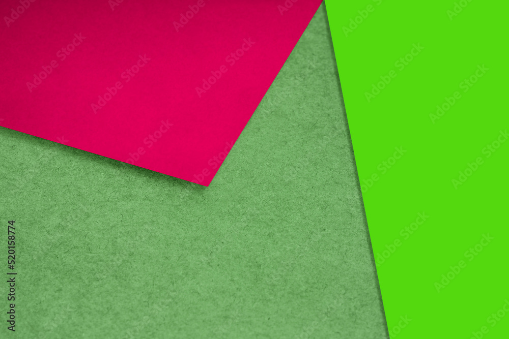 Plain and Textured neon green red pink papers randomly laying to form M like pattern and triangle for creative cover design idea