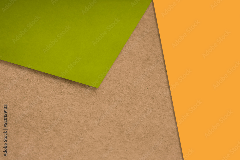 Plain and Textured neon orange green brown papers randomly laying to form M like pattern and triangle for creative cover design idea Plain and Textured neon orange green brown papers randomly laying to form M like pattern and triangle for creative cover design idea