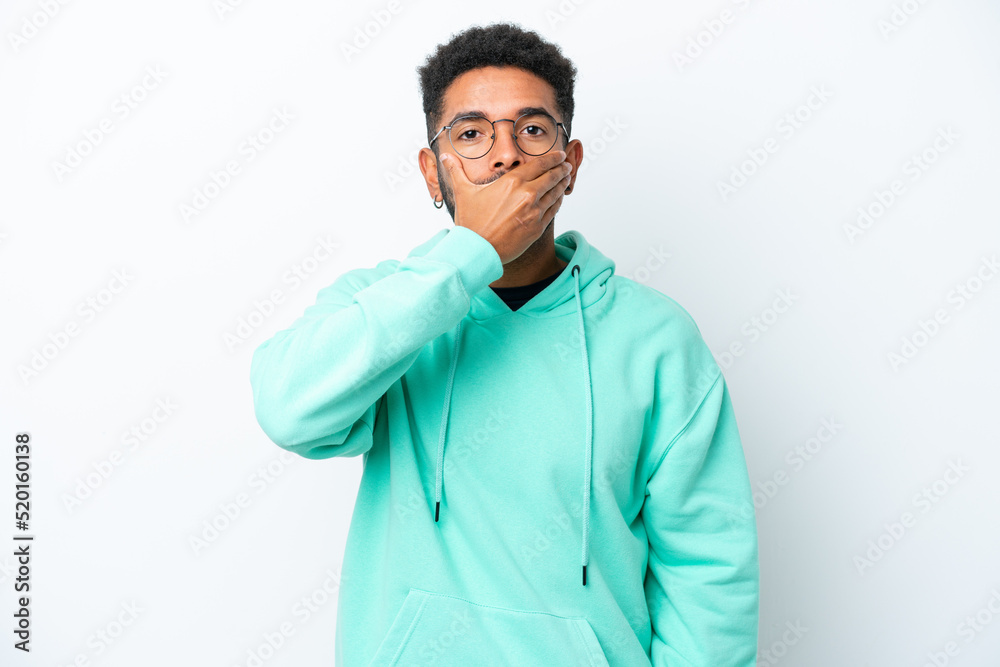 Young Brazilian man isolated on white background covering mouth with hand Young Brazilian man isolated on white background covering mouth with hand