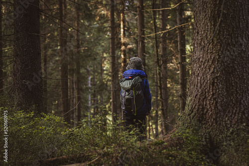 a boy on his way to camping in the woods. equipped with his backpack and equipment. ready for adventure. © Dariusz